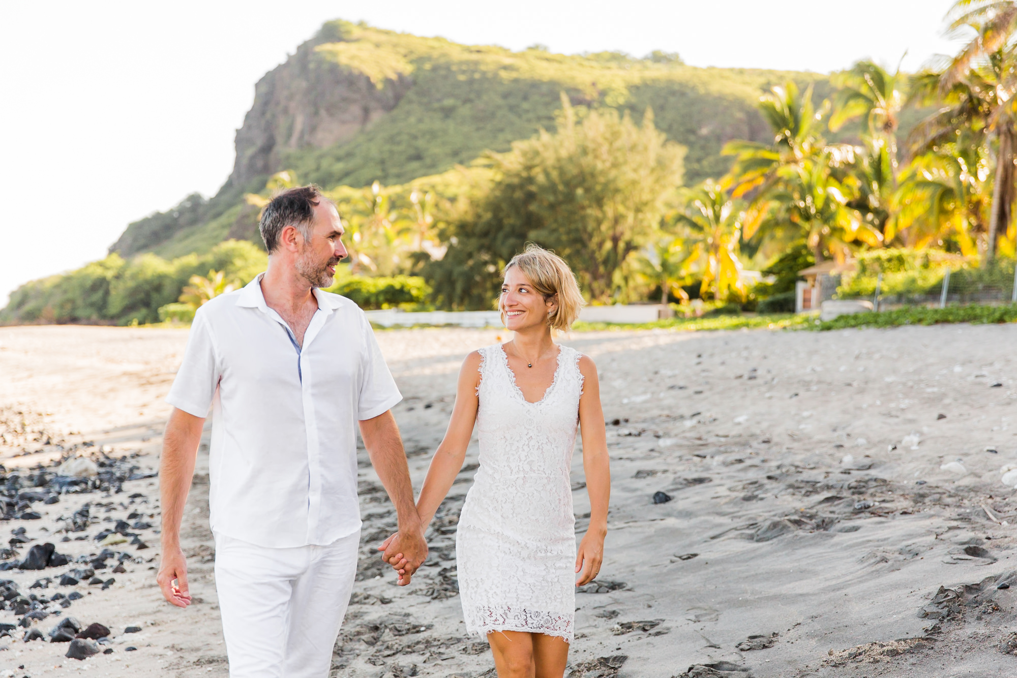Un couple qui marche sur la plage au lever du soleil lors d'une séance photo de famille à la Réunion