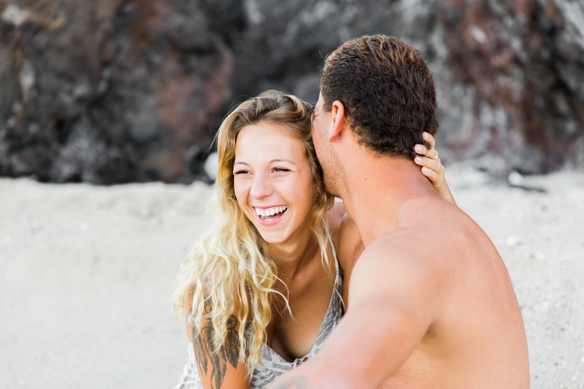 Un couple qui se dit des secrets sur une plage de l'île de la Réunion lors de leur séance photo