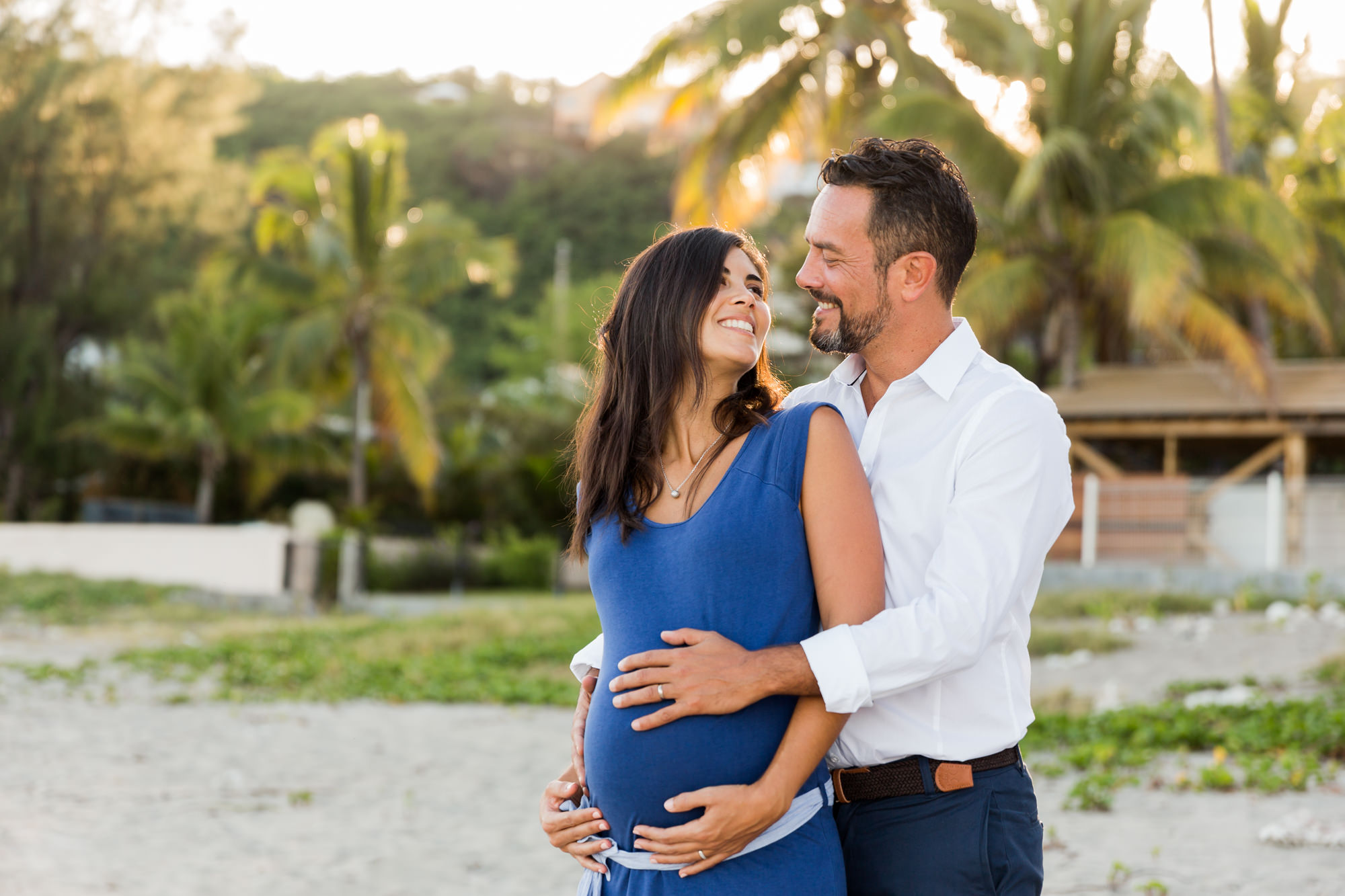 Couple souriant durant une séance grossesse sur une plage à la Réunion