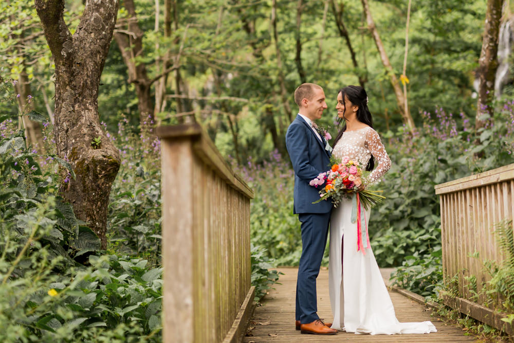 Des mariés à l'anse des cascades de Sainte-Rose avec un bouquet de fleurs tropicales