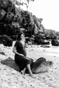 Une splendide femme enceinte sur la plage pendant son shooting grossesse
