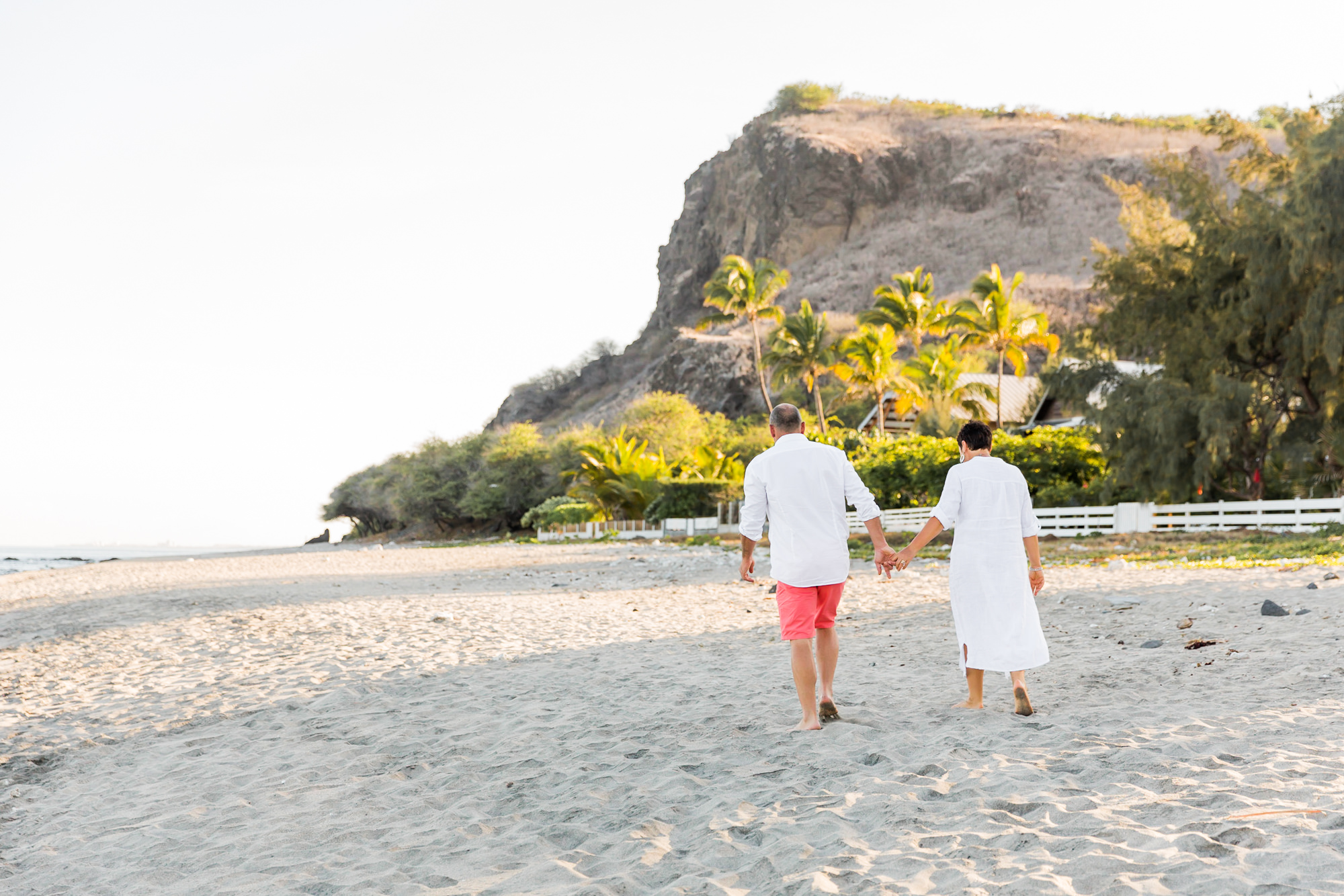 Un couple de grands-parents qui marche sur une plage de la Réunion