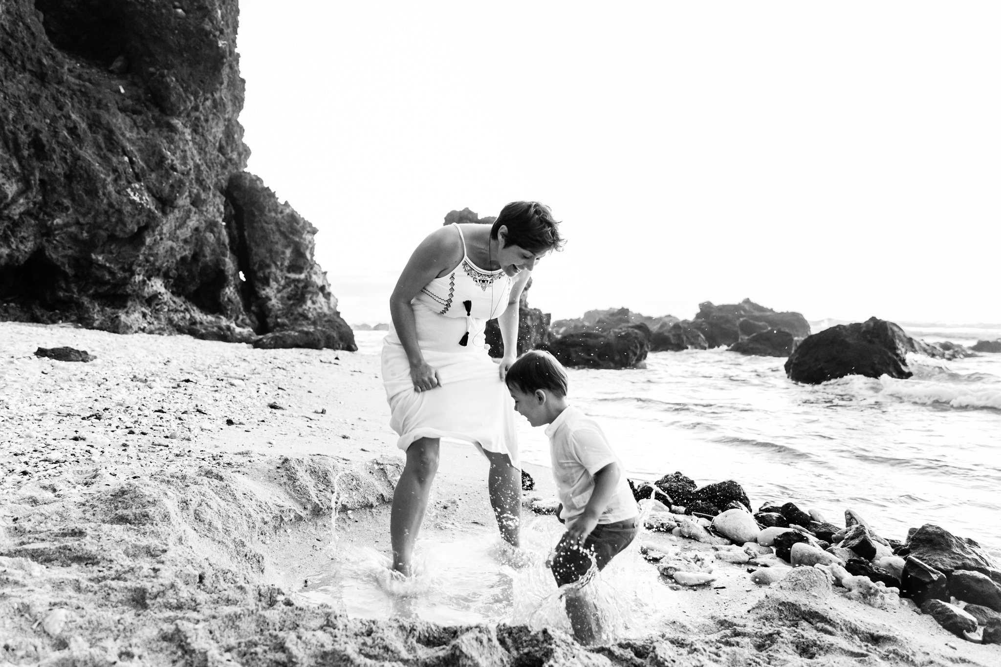 Un petit garçon et sa maman qui s'amuse lors d'une séance famille sur la plage