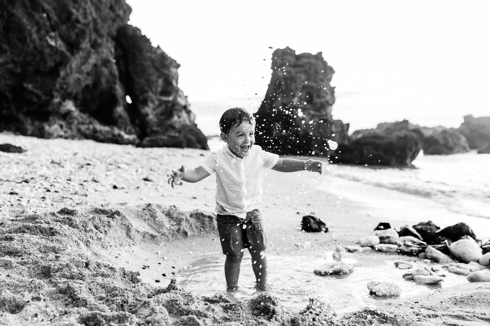 Un enfant qui s'amuse dans l'eau sur une plage de l'île de la Réunion lors d'une séance famille