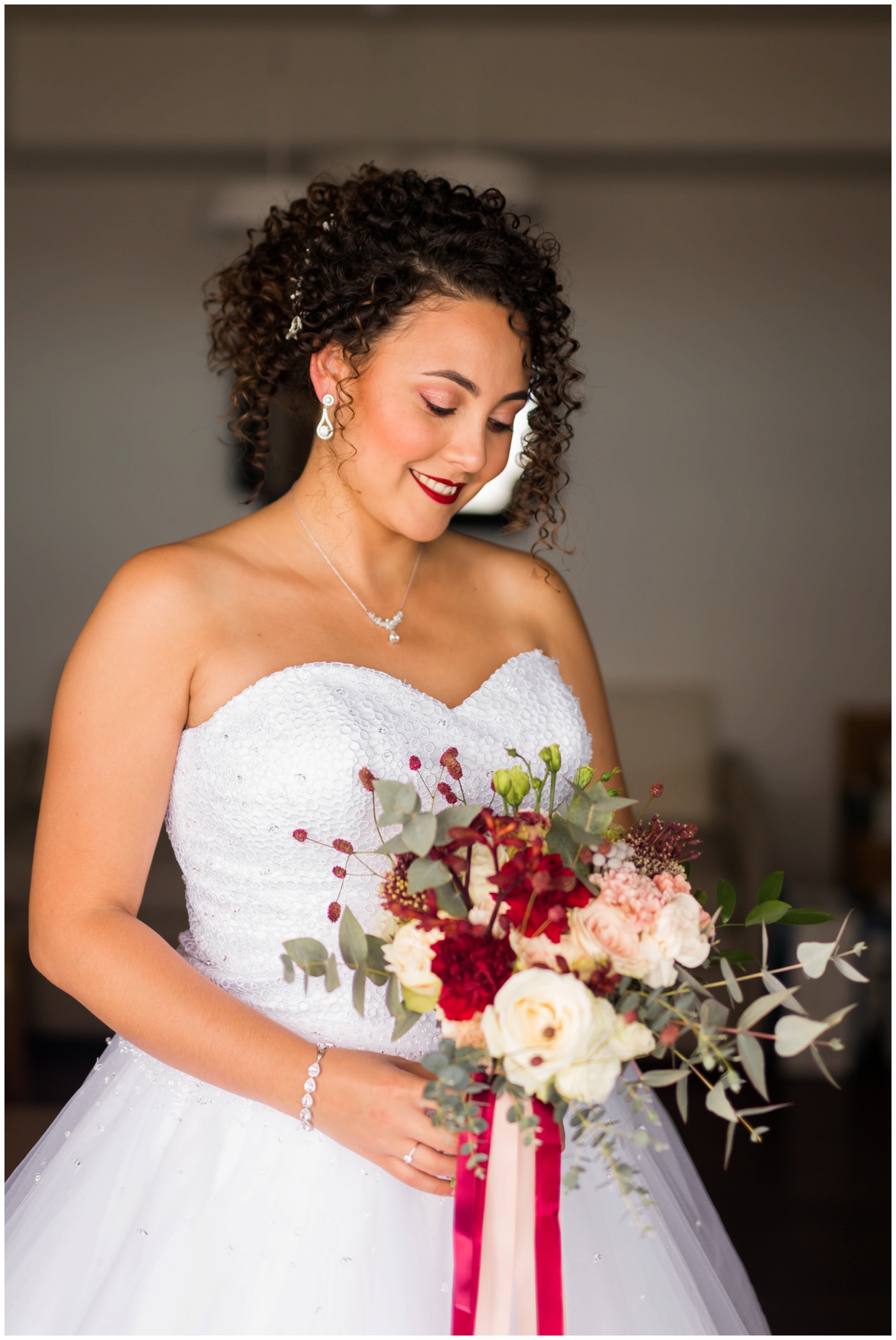 Une belle mariée et son bouquet de fleur dans les tons rose poudré marsala