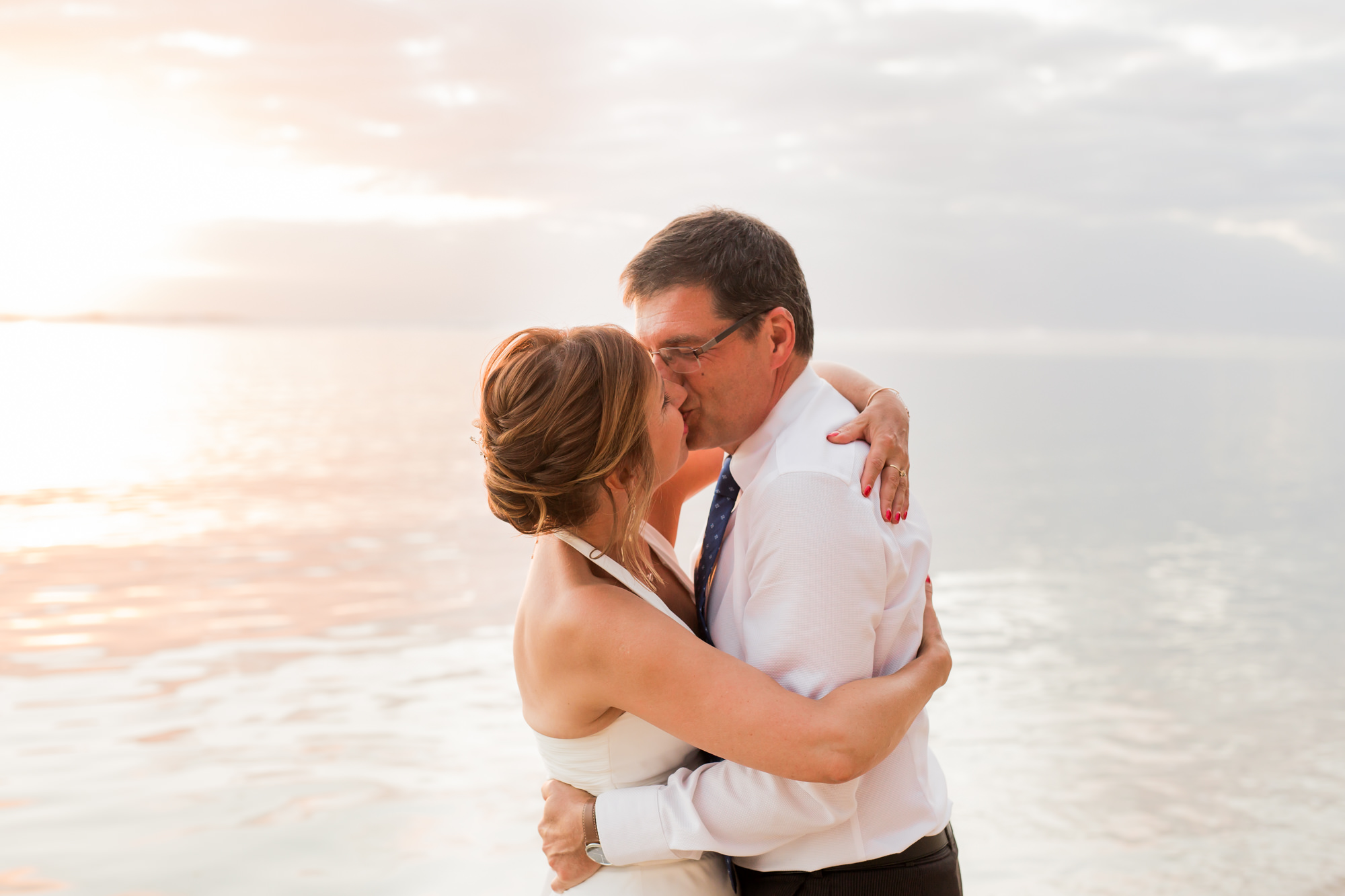 Un couple qui s'embrasse sur la plage lors de leur renouvellement de voeux de mariage