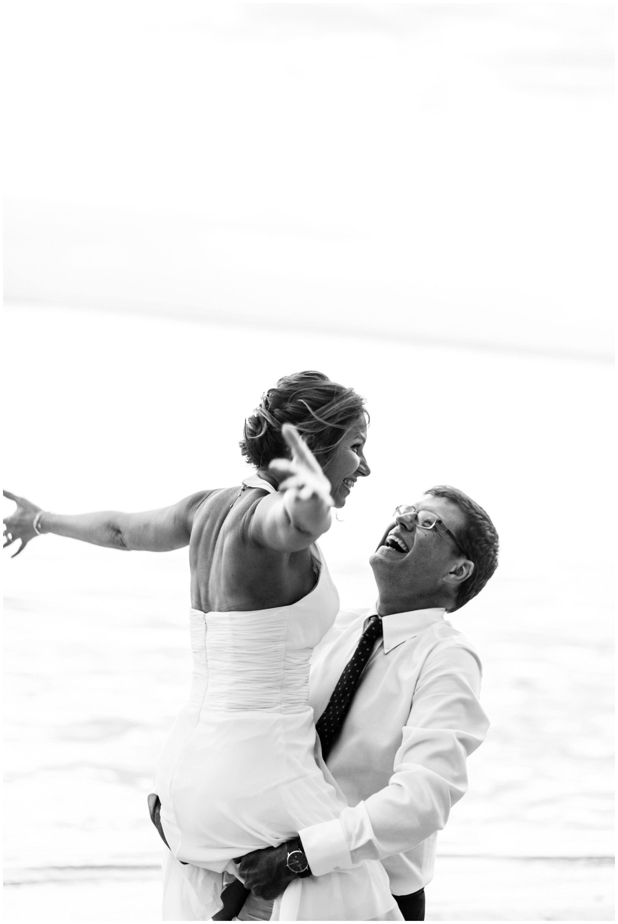 Un couple fun qui s'amuse sur la plage lors de leur renouvellement de voeux de mariage