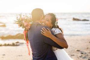 Un couple qui s'enlace sur la plage le jour de leur mariage