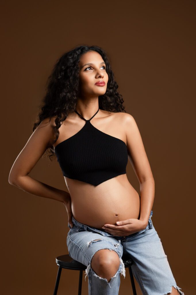 Une femme enceinte souriante au studio photo de Fanny Tiara