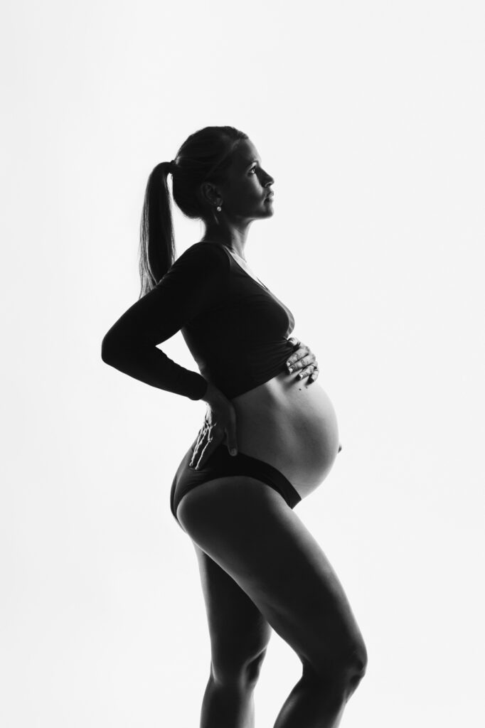 Une femme enceinte en noir et blanc au studio photo de Fanny Tiara à Sainte Marie