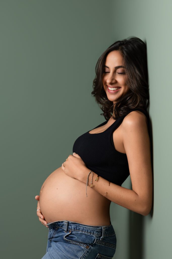 Une femme enceinte souriante au studio photo de Fanny Tiara à Sainte Marie