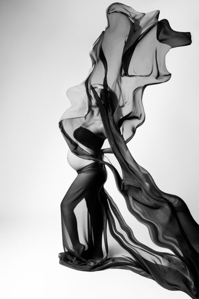 Un voile qui vole pour une tenue unique lors d'une séance grossesse en studio.